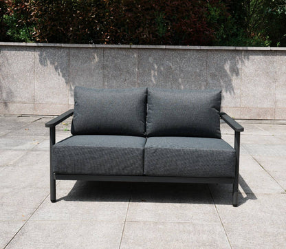 Aluminium 2 Seat Sofa in grey with a matching patterned rising table on a concrete surface