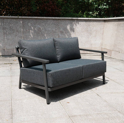 Aluminium 2 Seat Sofa with grey cushions and a patterned rising table on a patio